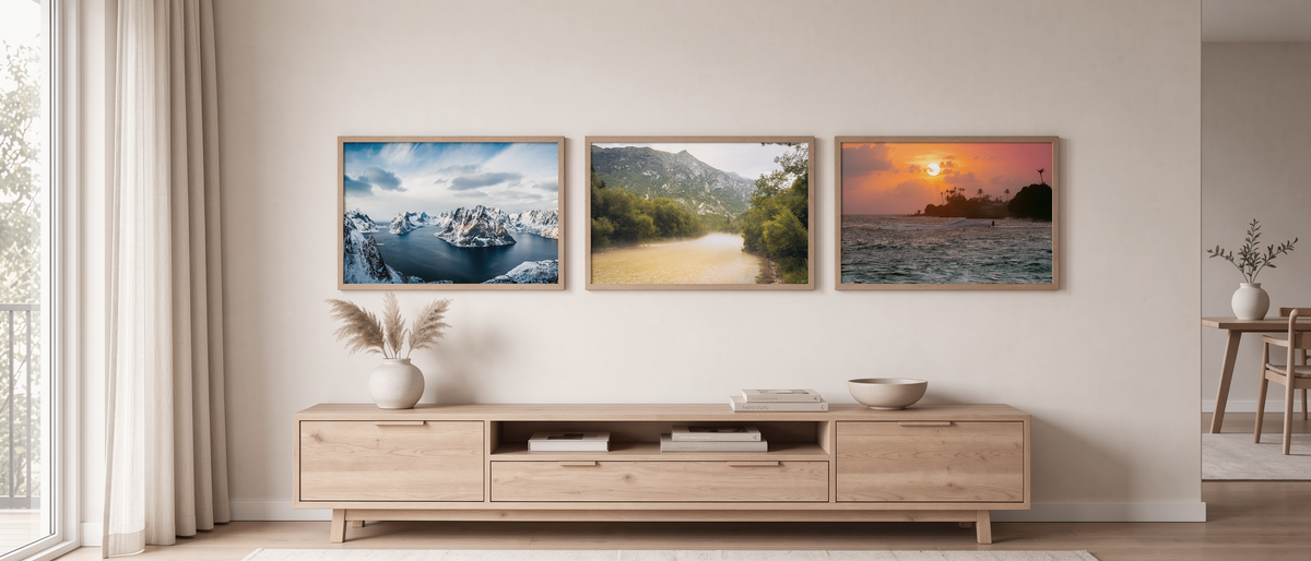 Drei Poster aus eigener Reisefotografie an einer Wohnzimmerwand: Lofoten, Soča-Tal und Sonnenuntergang in Sri Lanka
