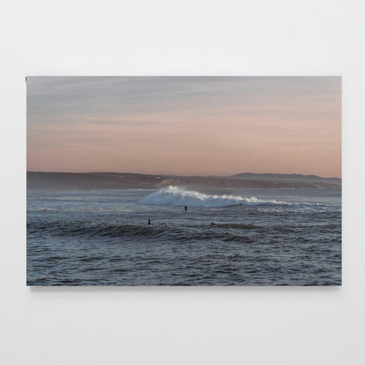 Poster Welle im Abendlicht mit Surfern im Rahmen, brechende Welle bei Sonnenuntergang am Atlantik